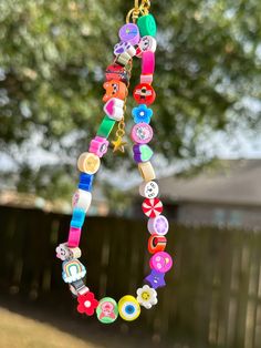 a colorful necklace hanging from a tree outside