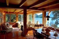 a living room filled with furniture next to a large window covered in lots of windows