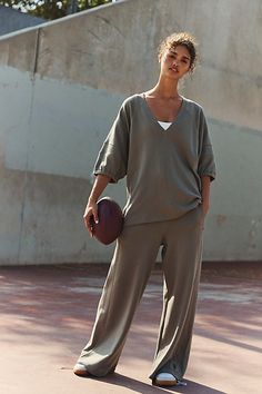 Take your casual workout wardrobe rotation to the next level with this effortlessly essential set featured in a slouchy, relaxed fit with short-sleeve shirt and coordinating high-rise, wide-leg pants for the perfect done-in-one look. **Fit:** Relaxed, slouchy fit **Features:** Top: V-neckline; dropped shoulders; defined seaming at sleeves; side slits at bottom; elasticated sleeve cuffs Pants: High-rise style; flowy fit; side pockets; drawstring waistline **Why We ❤ It:** The perfect throw-on-and High Rise Style, Workout Clothing, Fits With Shorts, Workout Sets, On The Run, Cuffed Pants, Free People Movement, Fp Movement, The Run