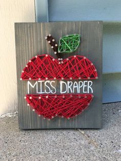 a string art apple with the word miss draper written on it's front side