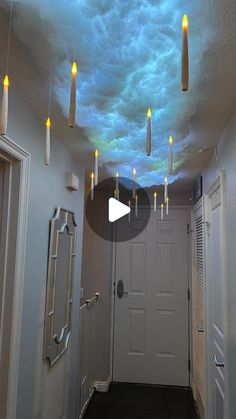 a hallway with some lights on the ceiling and clouds painted on the ceiling above it