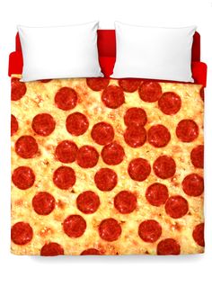 a bed covered in a red and white comforter with a pepperoni pizza design on it