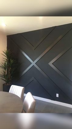 a dining room table and chairs in front of a wall with an x design on it