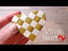 someone is holding up a heart shaped origami piece with the words woven heart on it