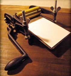 an old typewriter sitting on top of a wooden table next to a pen and paper