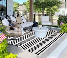 an outdoor patio with chairs, tables and rugs