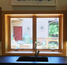 a kitchen sink sitting under a window in front of a counter top with a faucet