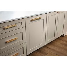 an image of a kitchen setting with white cabinets and wood flooring on the floors