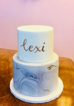 a marbled cake with the word texi on it sitting on a wooden table