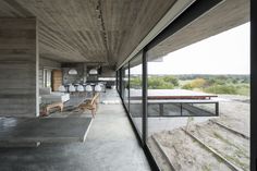 the interior of a modern house with concrete walls and floor to ceiling windows overlooking an outdoor pool