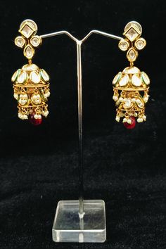 Description: Upgrade your ethnic jewelry collection with our elegant Radiant Royal Kundan Jhumki Earrings. Handcrafted and adorned with traditional Kundan stones, these earrings add a touch of royalty to any outfit. Perfect for special occasions or everyday wear. Experience the beauty and craftsmanship of Indian ethnic jewelry. About: Eye-catching and unique jewellery that will set you apart. Gift this piece to a loved one, and see their face light up with joy. Best for gifting or for personal u Festive Tilla Jhumkas In Drop Shape, Festive Heavy Temple Jewelry Earrings, Festive Tilla Drop Earrings Jhumkas, Temple Jewelry Kundan Jhumkas With Matching Earrings, Traditional Kundan Hoop Earrings With Intricate Design, Traditional Kundan Earrings For Celebrations, Bollywood Chandbali Earrings For Ceremonies, Traditional Meenakari Hoop Earrings For Festive Occasions, Traditional Meenakari Hoop Earrings For Diwali