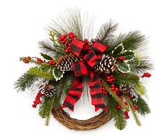 a christmas wreath with pine cones, holly and red berries