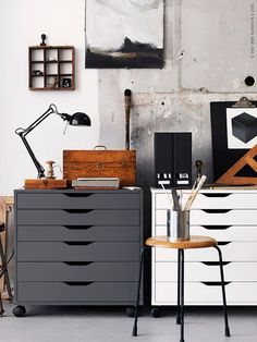 a white dresser sitting next to a black and white chest of drawers