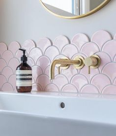 a bathroom sink with a soap dispenser next to it and a mirror on the wall