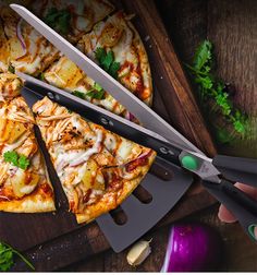 the pizza is cut into slices and ready to be eaten with two large knifes