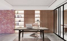 an office with a brick wall and wooden shelves on either side of the desk, along with a laptop computer