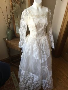 1950's white lace tiered tulle dress. Has some problems including a ripped left shoulder of the top lace layer and a couple of small ripped spots in the lace (see photos)Size XS24/25" waist, 34" bust Debutante Ball Wedding Dress With Lace Trim, Vintage Ball Gown For Wedding, Vintage White Ball Gown Wedding Dress, Lace Ball Gown Wedding Dress With Lace Trim, Vintage Lace Wedding Dress For Debutante Ball, Vintage White Lace Dress For Wedding, Vintage Wedding Dress With Lace Bodice, Vintage White Wedding Dress For Vintage Events, White Vintage Wedding Dress For Vintage Events