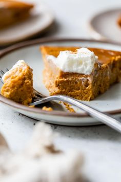 a slice of pumpkin pie on a plate with a fork next to the rest of the pie