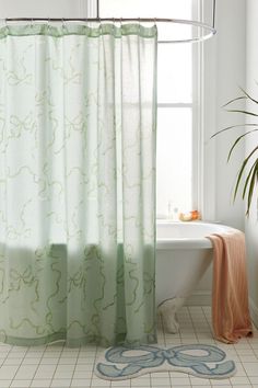 a bathroom with a bathtub, shower curtain and rug