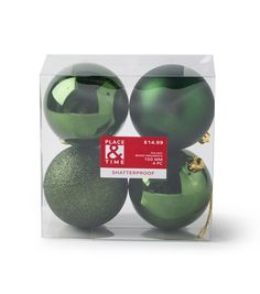 three shiny green ornaments in a clear box