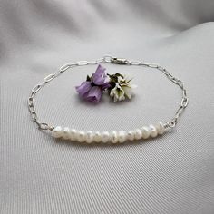 ✦This easy to wear bracelet is made with beautiful tiny and irregular tiny white pearls, measuring 3 to 4mm in size. Half of the bracelet is made of pearl and the other half is made of a a delicate sterling silver paperclip chain with links that measure 4mm x 2mm.  ✦The bracelet closes with a sterling silver elongated lobster clasp that can be placed at any position along the chain to make for an adjustable size if desired.  ✦The bracelet length is available in lengths from 6.5 inches to 9 inches. Please select bracelet length at check out. See below for information on how to determine the best size for your write.  ✦For custom length, please contact seller. HOW TO MEASURE ✦The best way to measure for a bracelet is to take a piece of string (or dental floss, whatever) and wrap it around yo Minimalist Sterling Silver Pearl Chain Bracelet, Minimalist Sterling Silver Pearl Bracelet With Charm, Minimalist Silver Pearl Bracelet With Adjustable Chain, Dainty Sterling Silver Pearl Bracelet With Charm, Everyday Delicate Sterling Silver Pearl Bracelet, Minimalist Sterling Silver Pearl Bracelet, Minimalist Silver Pearl Chain Bracelet, Dainty Sterling Silver Pearl Drop Bracelet, Minimalist Pearl Bracelet With Adjustable Chain