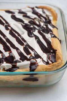 a dessert in a glass dish with chocolate sauce and whipped cream