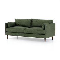 a green couch sitting on top of a white floor