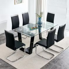 a glass dining table with black chairs and a rug on the floor in front of it