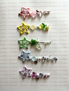 six different colored star shaped earrings on a white surface