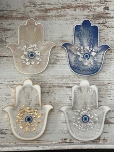 three hand shaped dishes with blue eyes and gold accents