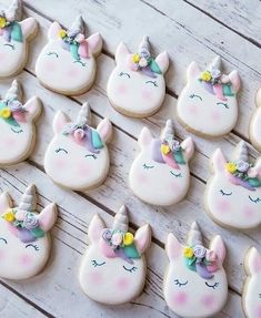 cookies decorated with unicorn ears and bows are displayed on a wooden table for an instagram