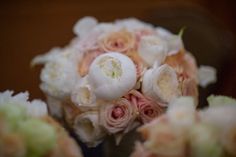 a bouquet of white and pink flowers sitting on top of a wooden table in front of a mirror