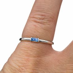 a woman's hand with a ring that has a blue topazte on it