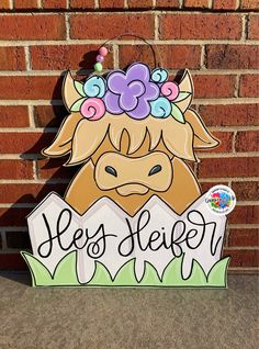 a wooden sign with a cow wearing a flower crown