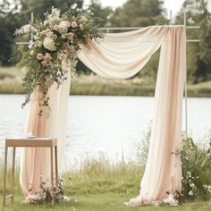 an outdoor ceremony setup with draping and flowers