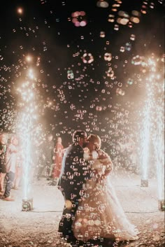 a bride and groom kissing in front of sparklers