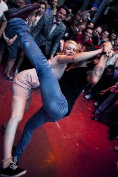 a woman is dancing in front of a crowd