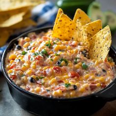 a black bowl filled with salsa and tortilla chips on top of a table