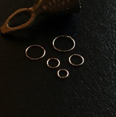 five silver rings sitting on top of a black table next to a pair of scissors