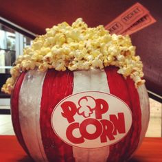 a popcorn bucket filled with popcorn sitting on top of a table