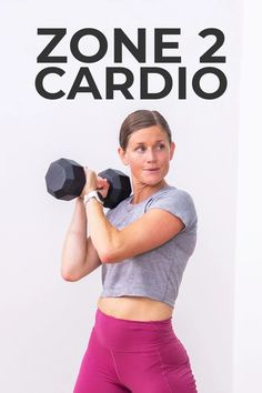 a woman holding two dumbs in front of a white wall with the words zone 2 cardio on it