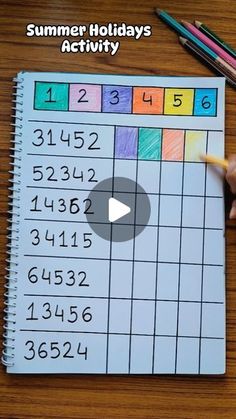 a person is writing numbers on a sheet of paper with pencils next to it