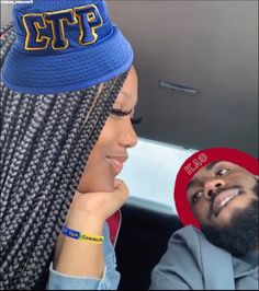 a woman with braids and a man wearing a hat