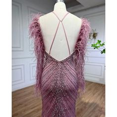 the back of a dress with feathers on it