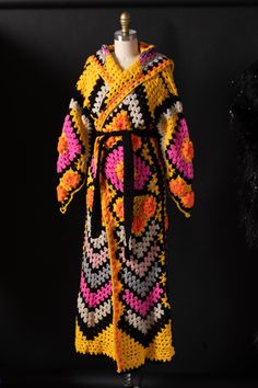 a crocheted robe is displayed on a mannequin