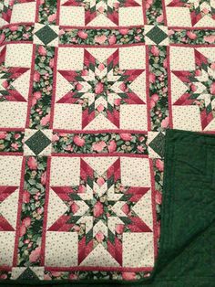 a quilted table topper sitting on top of a green piece of cloth next to it