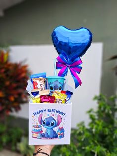 a person holding up a birthday card and balloon