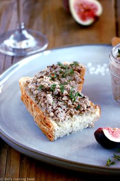 a piece of bread on a plate next to a glass of wine and figs