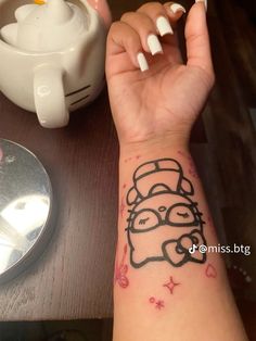 a person's arm with a tattoo on it and a cup in the background