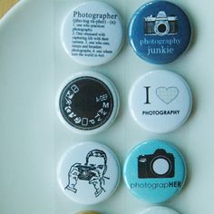 four different buttons on a white plate with words and pictures in the middle one says photographer, i love photography